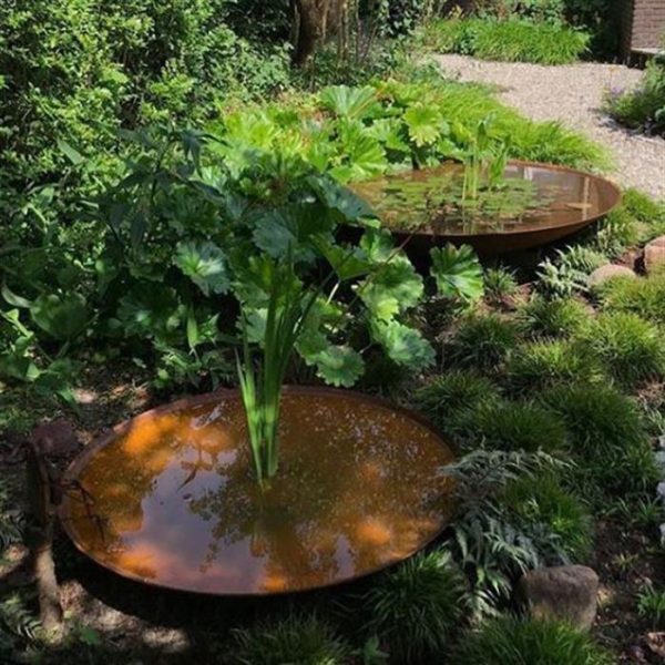 two weathered Corten steel waterbowls in garden