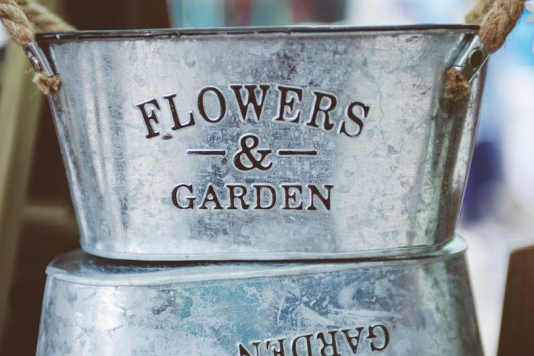 galvanised plant pot with the text "Flowers & Garden" on the front